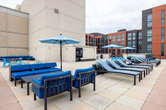 A patio with blue couches and umbrellas. at Loree Grand at Union Place, Washington