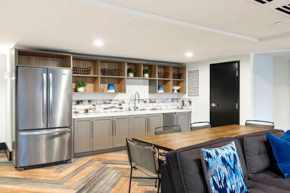 A modern kitchen with a refrigerator, sink, and bar area. at Loree Grand at Union Place, Washington, DC
