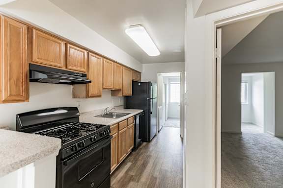 A kitchen with wooden cabinets and black appliances.