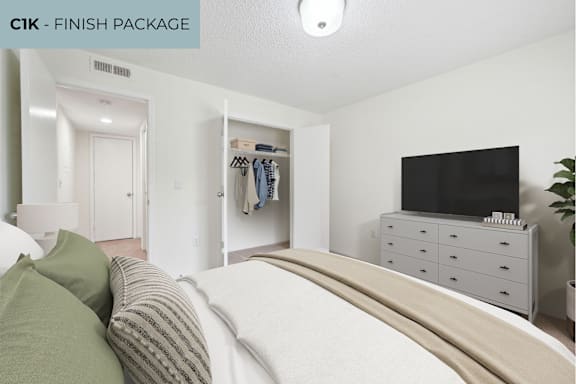 A bedroom with a bed, a dresser, and a TV.