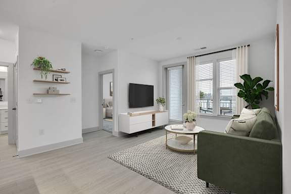 A modern living room with a green couch and a television