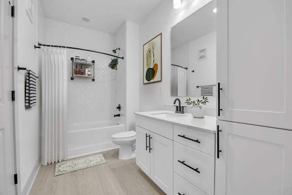 A white bathroom with a toilet, sink, and shower