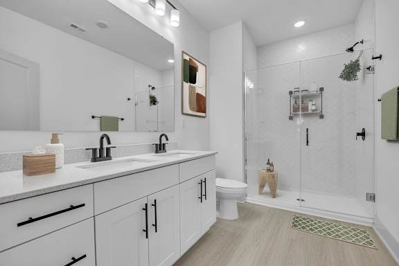 A white bathroom with a toilet, sink, and shower