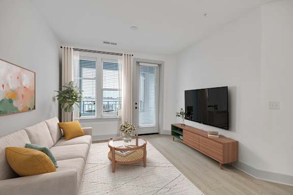 A living room with a couch, a coffee table, and a television