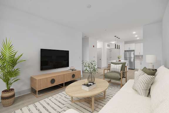 A modern living room with a flat screen TV, a wooden coffee table, and a potted plant