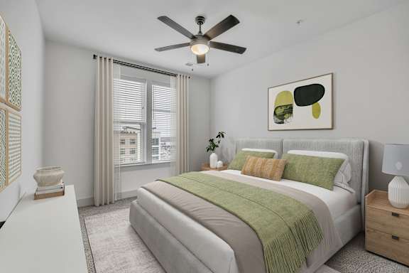 A bedroom with a bed, nightstand, and a ceiling fan