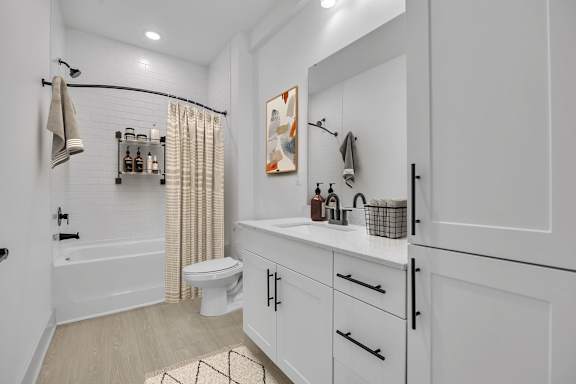 A white bathroom with a toilet, sink, and shower