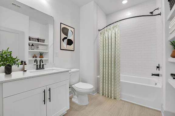A white bathroom with a toilet, sink, and bathtub