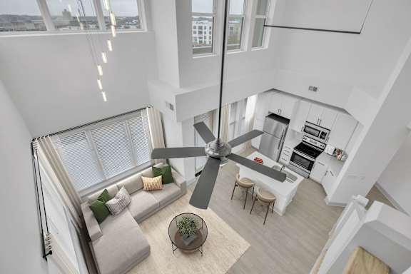 A modern living room with a large window and a ceiling fan
