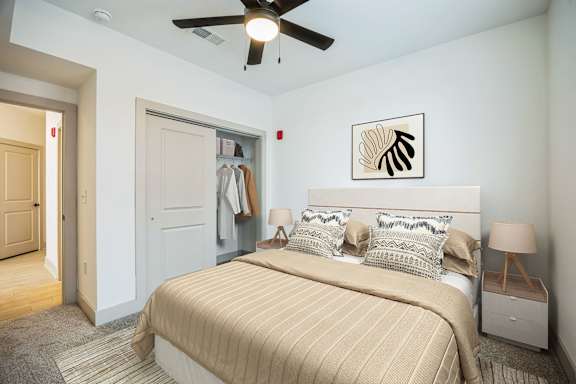 A bedroom with a bed, nightstand, and a ceiling fan