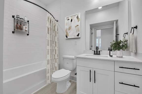 A white bathroom with a toilet, sink, and shower