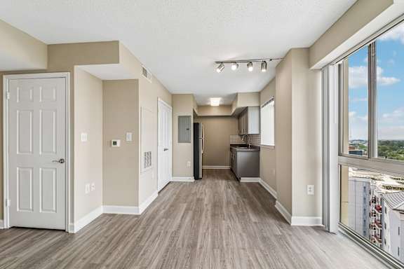 A spacious room with a kitchen area and a view of the city.