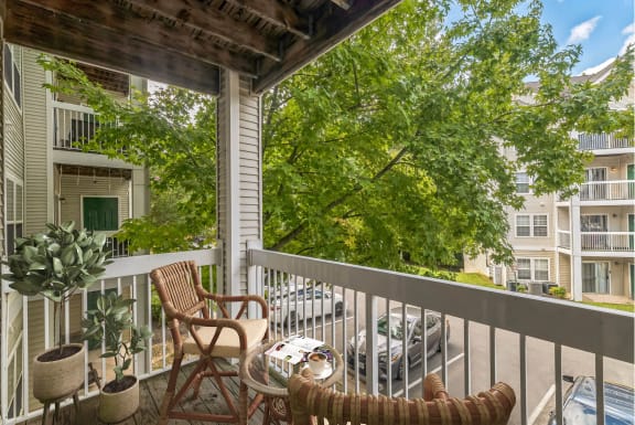 a porch with two chairs and a table on a balcony at Sanger Place, Lorton, VA