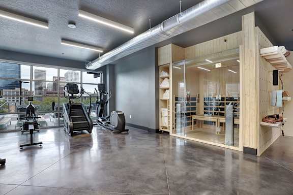 A gym with a view of the city outside the window.