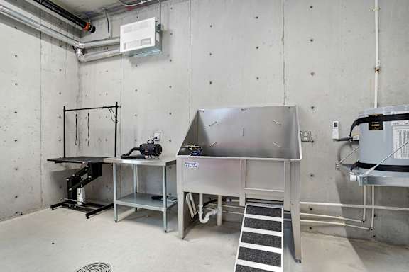 A room with a stainless steel table and a metal shelf.