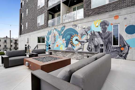 A mural of a man on a horse is painted on the side of a building.