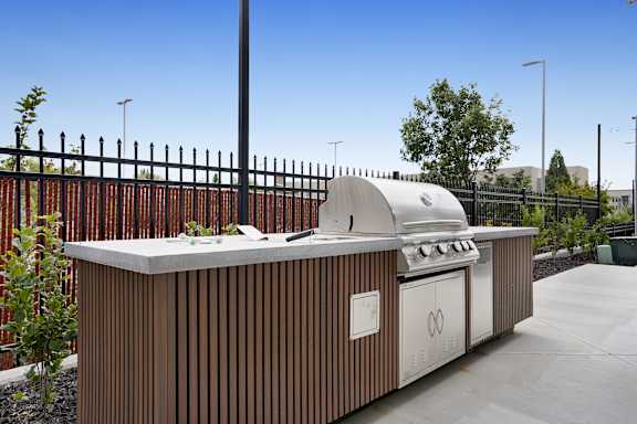 A modern outdoor kitchen with a grill and sink.