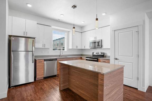 A modern kitchen with a wooden island and stainless steel appliances.