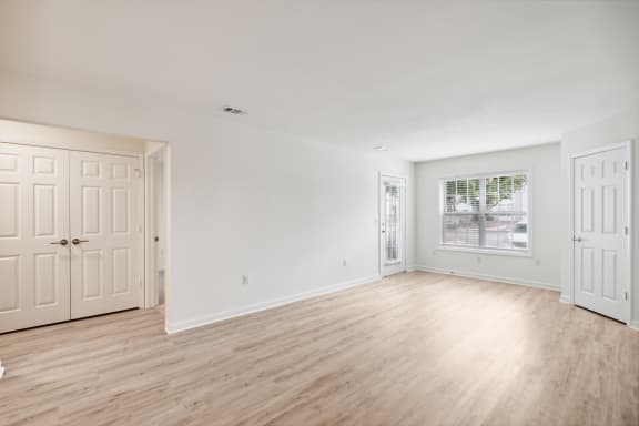 a bedroom with hardwood floors and white walls