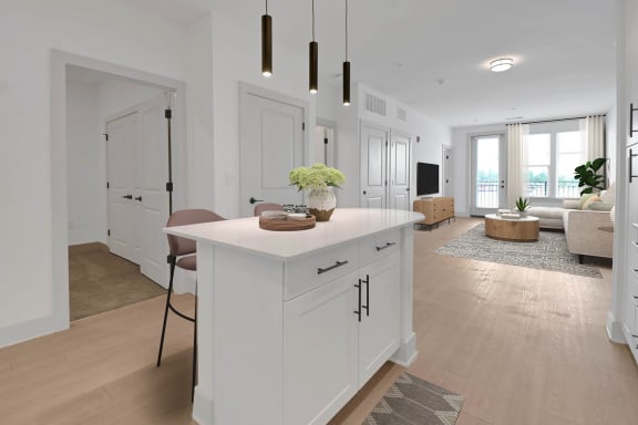 a white kitchen with an island and a living room at Metropolitan at the Riverwalk, Wilmington, NC