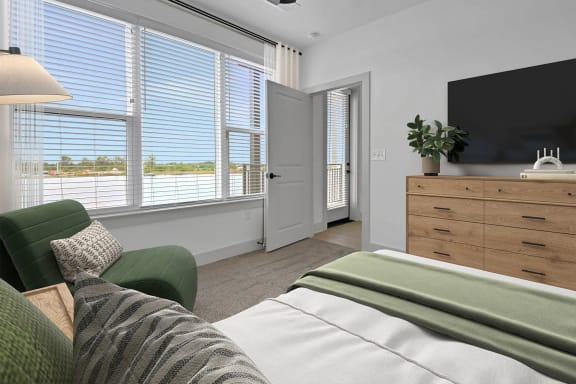a bedroom with a couch and a chair and a tv at Metropolitan at the Riverwalk, Wilmington, NC