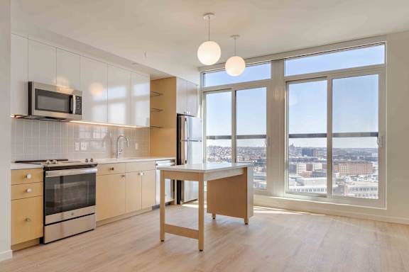 Modern apartment with kitchen island and city views at Allied Harbor Point Apartments, Baltimore, MD