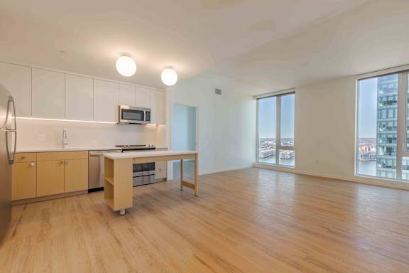 A kitchen with wooden floors and a refrigerator.