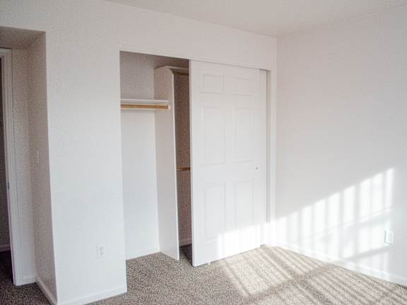 A white door is in a white room with a tan carpet.