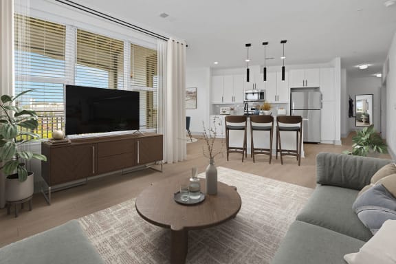 a living room with a tv and a kitchen in the background at Metropolitan at the Riverwalk, Wilmington, NC