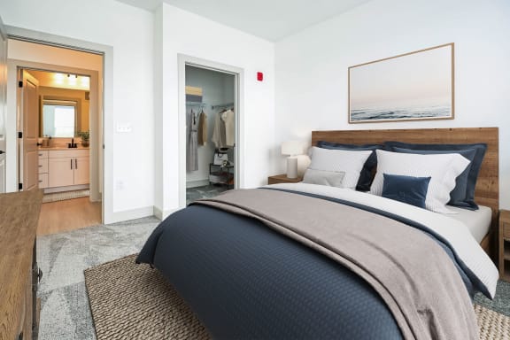 a bedroom with a bed and a closet with a mirror at Metropolitan at the Riverwalk, Wilmington, NC