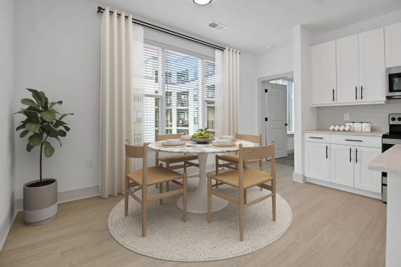 a dining room with a table and chairs at Metropolitan at the Riverwalk, Wilmington, NC