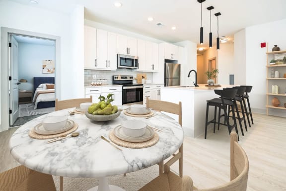 an open kitchen and dining area with a marble table at Metropolitan at the Riverwalk, Wilmington, NC