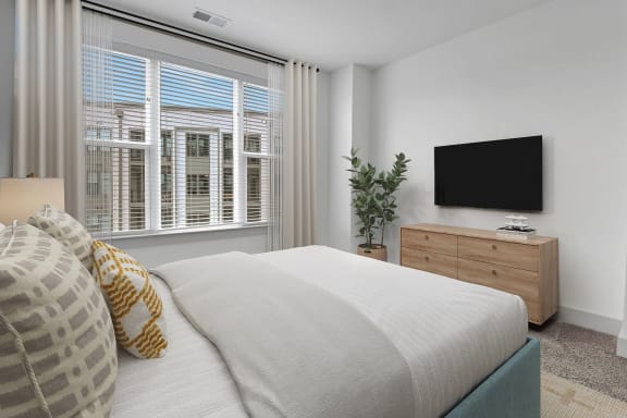 a bedroom with a bed and a large window at Metropolitan at the Riverwalk, Wilmington, NC
