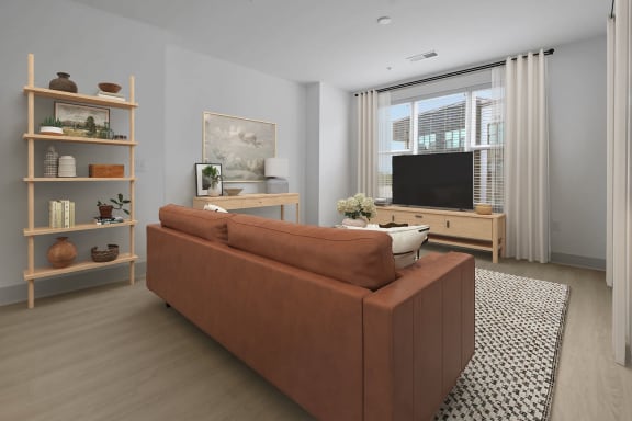 a living room with a brown couch and a television at Metropolitan at the Riverwalk, Wilmington, NC