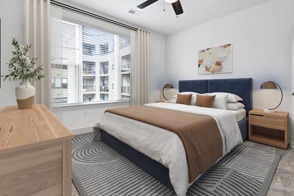 a bedroom with a bed and a large window at Metropolitan at the Riverwalk, Wilmington, NC
