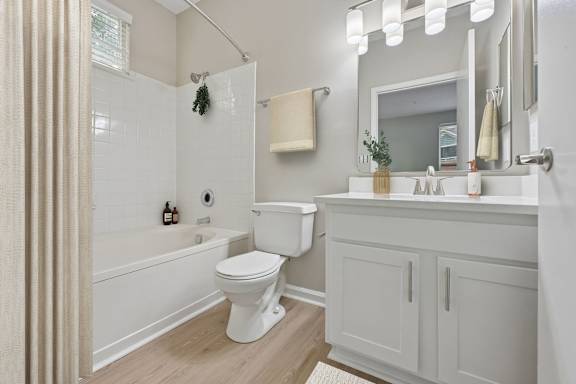 A white toilet sits in a bathroom next to a white sink.