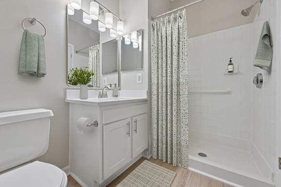 A white bathroom with a white tub and a white toilet.