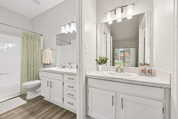 A bathroom with a toilet, sink, and mirror.