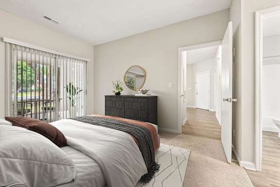 A bedroom with a bed, a dresser, and a mirror.
