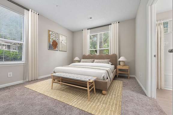 A bedroom with a large bed and a window with curtains.
