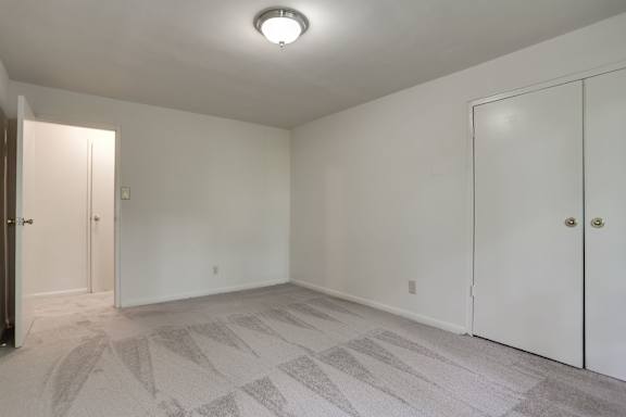 A room with a carpeted floor and a ceiling light.