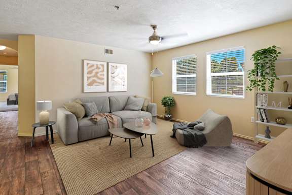A living room with a grey couch and a rug. at Bluffs Apartments, Bluffdale, 84065