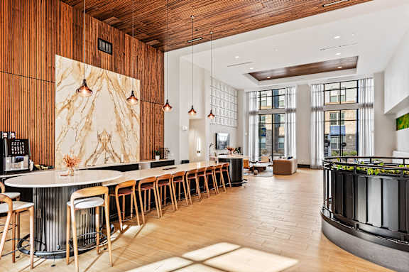 A modern kitchen with a long bar and wooden floors.