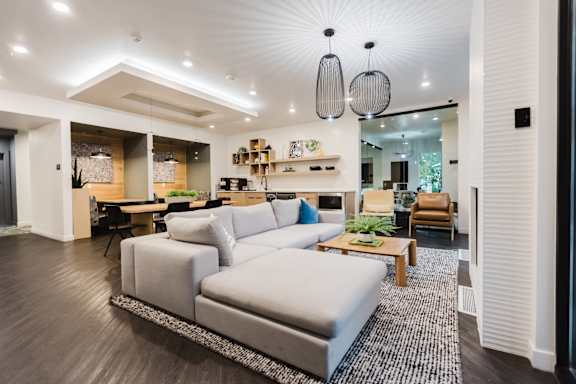 A modern living room with a grey sofa and a wooden coffee table.