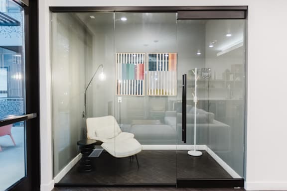 A white chair is in front of a glass wall.