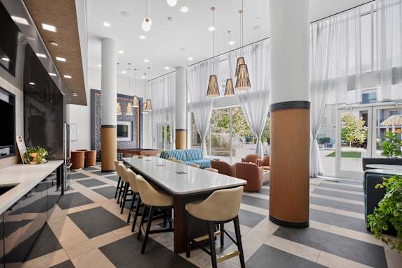A modern dining area with a long table surrounded by chairs.