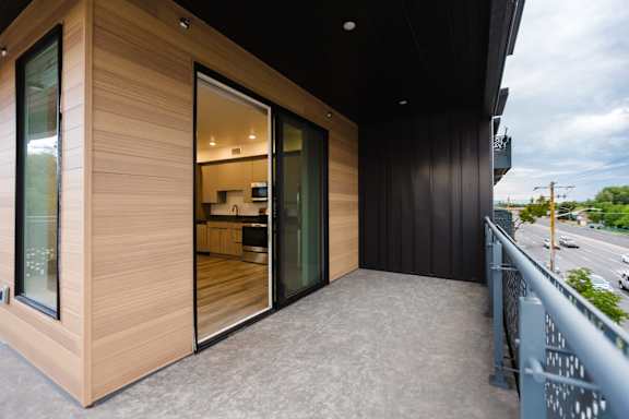 A modern house with a balcony and sliding glass doors.