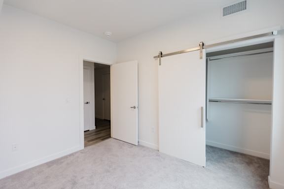 A white room with a sliding door and a small window.