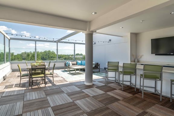 a patio area with a dining table and chairs and a flat screen tvat Delamarre at Celebration, Florida