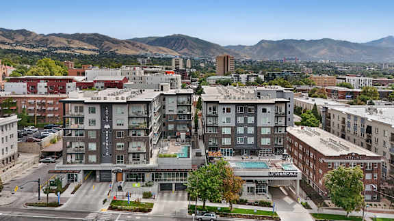 A view of a city with apartment buildings and a mountain range in the background.
